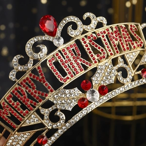 Detail of golden Christmas crown featuring red rhinestones and Merry Christmas lettering