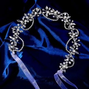 Détail macro du bandeau de mariée avec fleurs en alliage argenté et strass scintillants