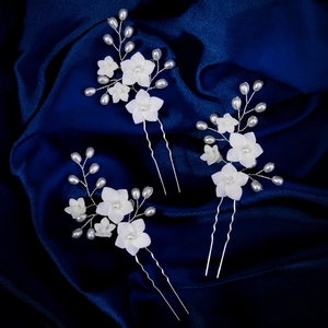Three-piece set of elegant bridal hair pins with white resin flowers and pearls