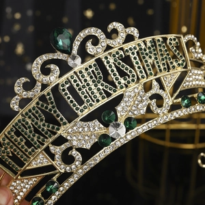 Macro view of gold Christmas crown featuring green rhinestones and Merry Christmas lettering