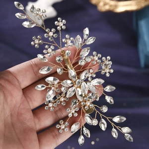 Detail der handgefertigten Braut-Haarklammer mit Golddraht, Strasssteinen und weißen Perlen