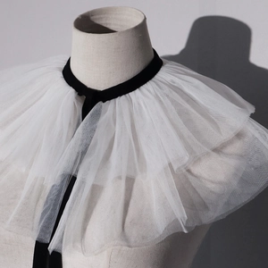 Detailed view of tiered white mesh ruff collar with elegant black velvet neck ties