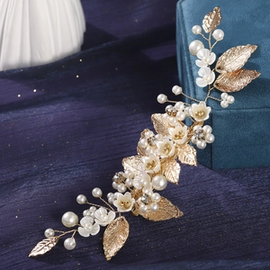 Handmade gold leaf bridal headpiece with white flowers and pearls on blue silk background