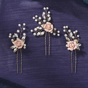 Detail of three handmade floral hair pins with pink clay roses and white pearls on gold wire