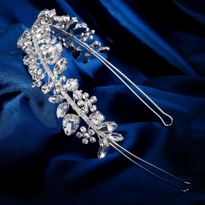 Detail of silver bridal headband with crystal floral vine on dark blue satin fabric