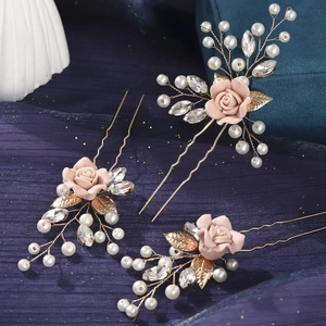 Macro shot of handmade U-shaped hair pins with pink resin roses and white pearls