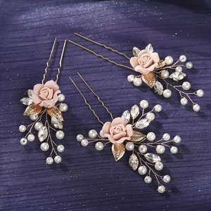 Detail of three handmade U-shaped hairpins with pink resin roses and white pearls