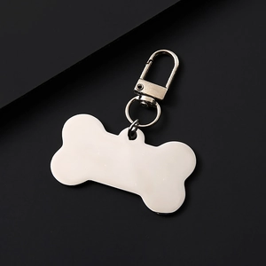 Close-up of bone-shaped metal pet tag with lobster clasp and blank engraving surface