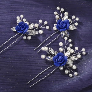 Detail of handmade blue rose hair pins with pearls and crystals on navy fabric