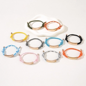 Detail view of colorful adjustable cord bracelets with polished metal plaques in rose gold