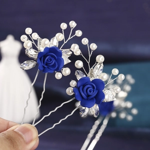 Detail of blue clay rose hair pin with white pearls and silver U-shaped metal fork