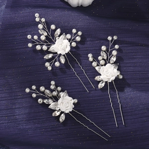 Detail of three handmade bridal hair pins with white clay flowers and pearls
