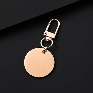 Polished rose gold metal keychain with round blank tag and lobster clasp on black background