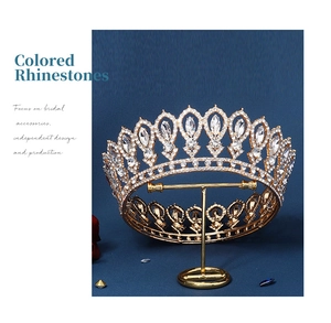 Detail of golden bridal crown with colored rhinestones on a matching display stand