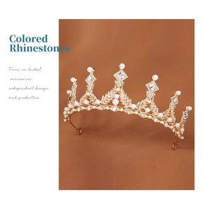 Close-up of golden alloy crown with white pearls and sparkling rhinestones for kids