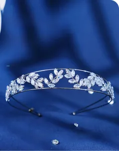 Détail de la couronne de feuilles en argent avec zircons sur fond de tissu bleu marine