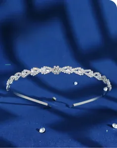 Detail of silver wavy crown headband with sparkling waterdrop rhinestones on blue silk