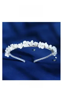 Detailed view of handmade white ceramic flowers and crystal beads on a bridal headband