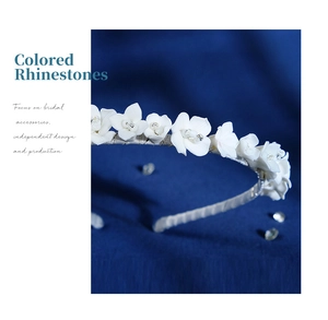 Detail of handmade white ceramic flowers and sparkling rhinestones on bridal headband