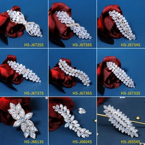 Collage of nine silver hair clips with zircon bow and floral designs on blue fabric