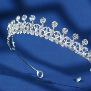 Elegant silver bridal tiara with sparkling rhinestones on dark blue satin background