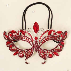 Detailed close-up of a butterfly masquerade mask with red rhinestones and silver base