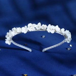 Elegant bridal headband with white ceramic flowers and beads on a silver base