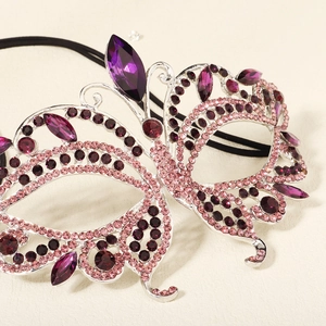 Macro detail of butterfly masquerade mask with sparkling purple and pink rhinestones
