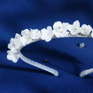 Elegant handmade bridal headband with white ceramic flowers and beads on silver base