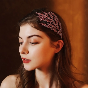 Detailed view of luxury bridal headband with red crystal leaves on a female model