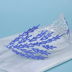 Detail of silver bridal headband featuring vibrant blue rhinestones and branch-like coral design