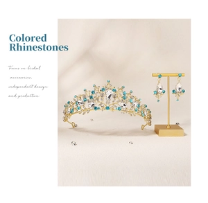 Detail view of crystal bridal crown and matching teardrop earrings in golden metal finish
