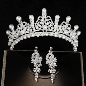 Detailopname van bruidssieraden set met kristallen kroon en parel oorbellen