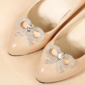 Close-up of sparkling rhinestone bow shoe clips with oval zircon on pointed high heels