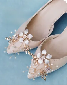 Detail of handmade bridal shoe clips with satin flowers and pearls for wedding heels