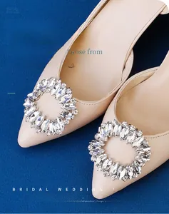 Close-up of sparkling silver rhinestone shoe clips for bridal high heels on beige pumps