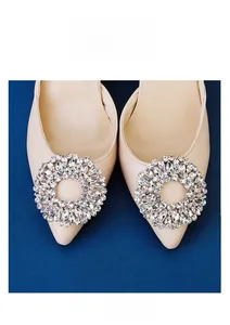 Close-up of sparkling crystal rhinestone buckle on beige pointed-toe bridal high heels