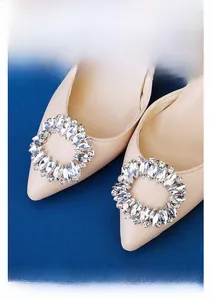 Close-up of elegant oval hollow rhinestone buckles on beige pointed-toe bridal shoes