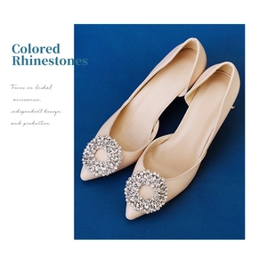 Detailed view of round rhinestone buckle on elegant beige pointed-toe bridal pumps