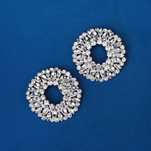 Sparkling silver crystal rhinestone shoe clips with oval and round stones on navy blue fabric