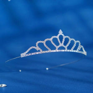 Detail view of silver crystal tiara crown with rhinestones on dark blue background