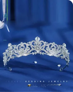 Macro detail of silver bridal crown with sparkling crystals on dark blue velvet