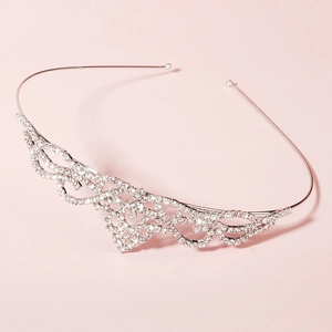 Close-up of silver tiara headpiece featuring intricate rhinestone wave and floral patterns