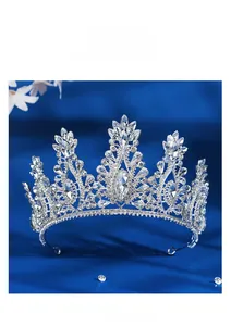 Detail of silver bridal crown with crystal vine patterns on a blue velvet background