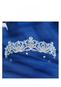 Detailed close-up of a silver bridal crown with crystals on a blue velvet background
