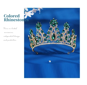 Detailed macro of golden baroque tiara featuring deep green emerald-cut rhinestones