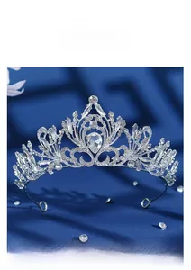 Detail of silver bridal tiara with sparkling crystal flowers on blue velvet background