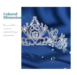 Close-up of luxury bridal crown with teardrop rhinestones on dark blue silk fabric