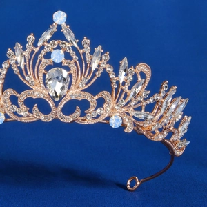 Close-up of rose gold bridal crown featuring intricate filigree and blue opal stones