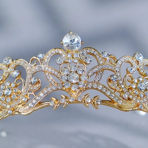 Golden baroque bridal crown with white rhinestones on elegant blue silk backdrop